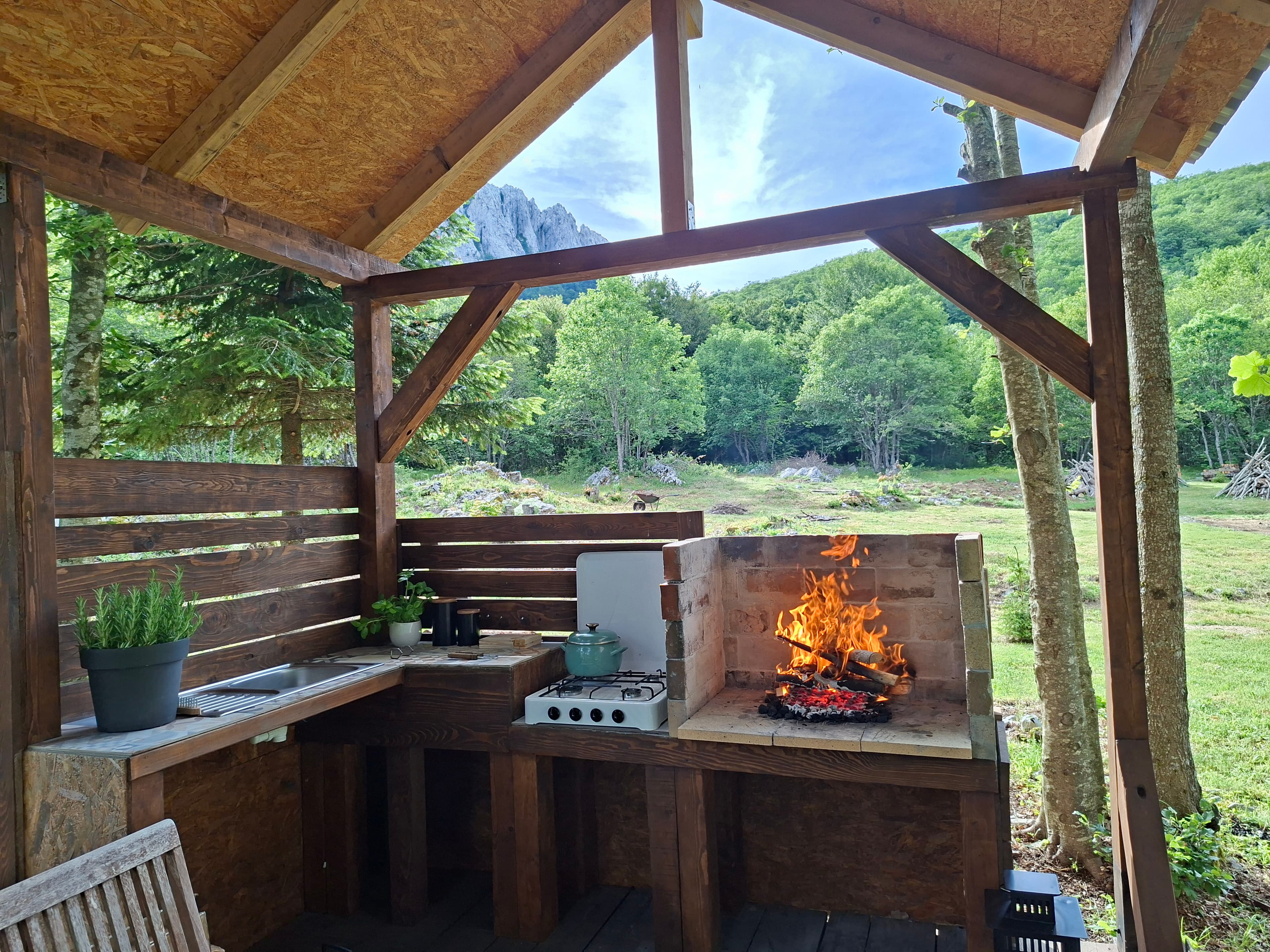 Outdoor kitchen with wood fire burning and Bačić Kuk on the horizon