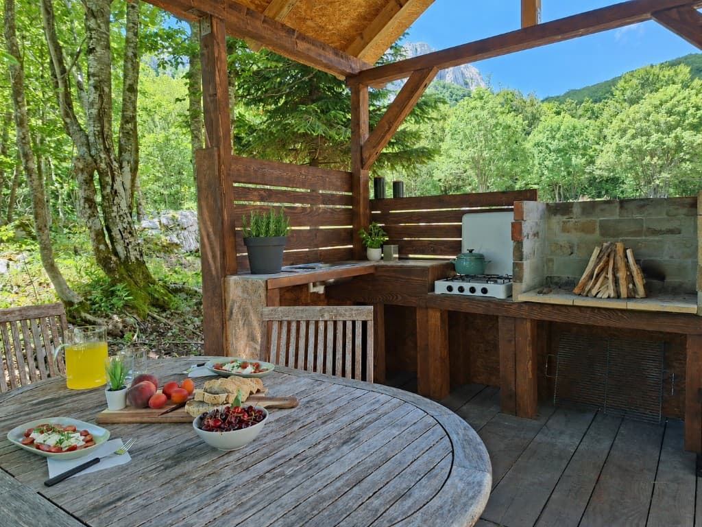 Outdoor kitchen and dining table set for lunch with forest and mountain peaks at Stars Peak