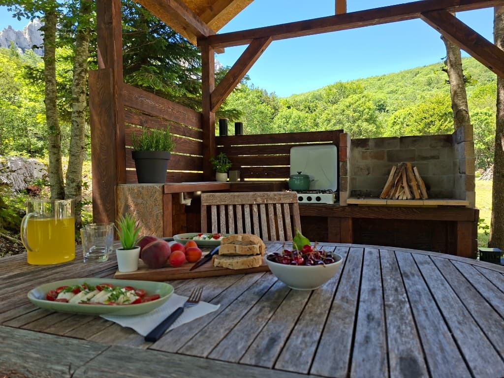 Round outdoor table set for lunch at the Stars Peak summer kitchen